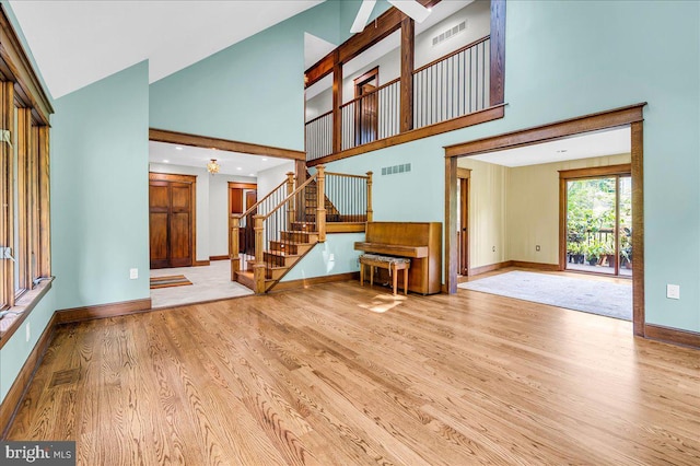 13 Quartz Mill Rd, Newark, DE 19711 - unfurnished living room featuring wood finished floors, baseboards, a high ceiling, and stairs
