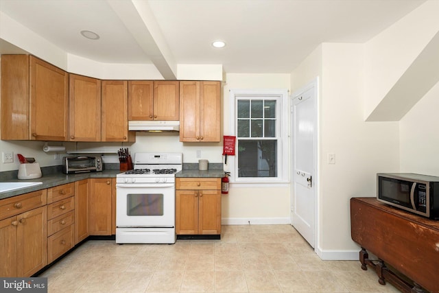 429 Greenway Ave, Ewing, NJ 08618 - kitchen with white gas range oven, under cabinet range hood, stainless steel microwave, dark countertops, and brown cabinets