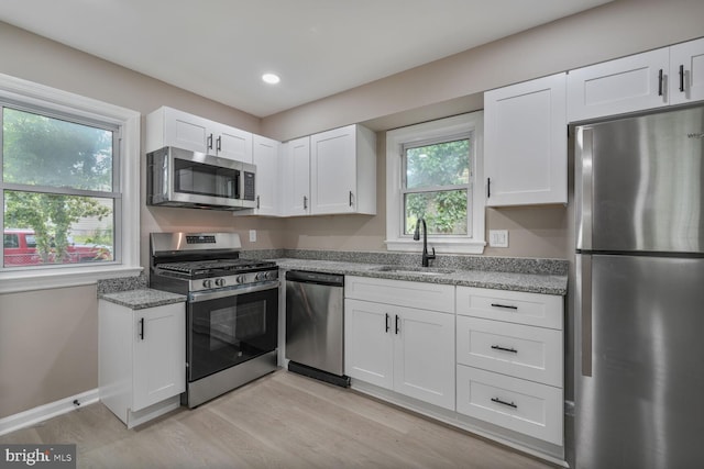 5010 54th Ave, Hyattsville, MD 20781 - kitchen featuring appliances with stainless steel finishes, a sink, light wood-style flooring, white cabinetry, and recessed lighting