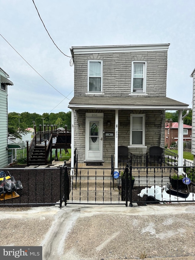 250 N 3rd St, Hamburg, PA 19526 - view of front facade with a porch, a fenced front yard, stone siding, and a gate
