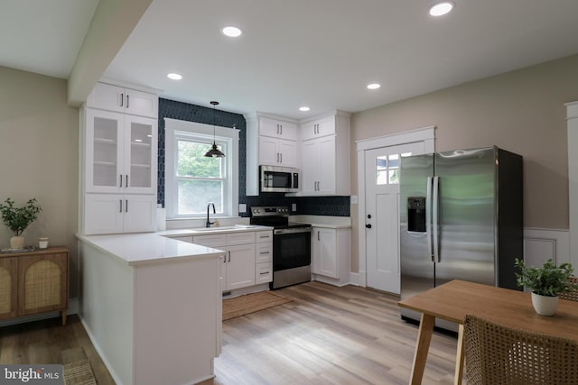 30 Gooney Falls Ln, Front Royal, VA 22630 - kitchen featuring stainless steel appliances, a sink, light wood-type flooring, a peninsula, and white cabinetry