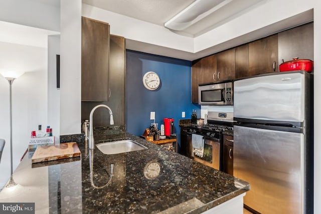 440 L St NW Unit 901, Washington, DC 20001 - kitchen with appliances with stainless steel finishes, a sink, dark brown cabinetry, and dark stone counters