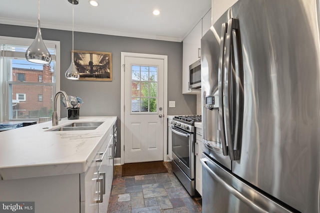 5054 8th St NE, Washington, DC 20017 - kitchen with stainless steel appliances, a sink, dark stone finish floors, crown molding, and white cabinets