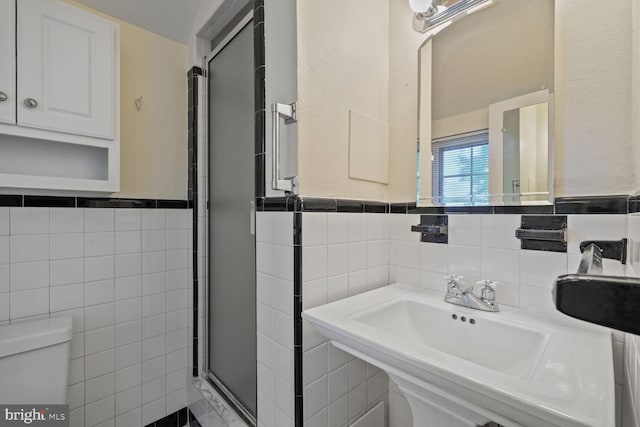 5811 Augusta Ln, Bethesda, MD 20816 - bathroom with tile walls, toilet, a shower stall, wainscoting, and a sink
