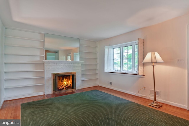 5811 Augusta Ln, Bethesda, MD 20816 - unfurnished living room with a fireplace, baseboards, wood finished floors, and built in shelves