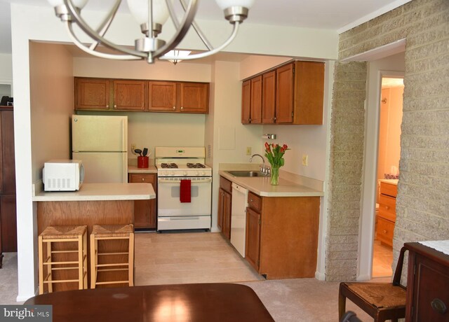4360 Ivymount Ct Unit 32, Annandale, VA 22003 - kitchen featuring white appliances, a sink, brown cabinetry, light countertops, and a breakfast bar