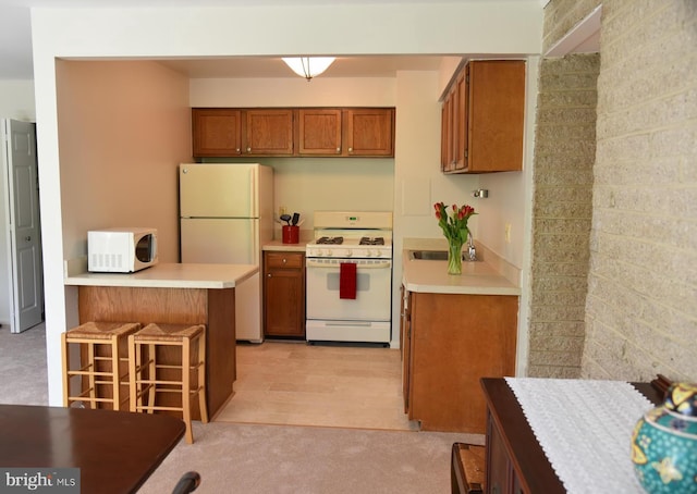 4360 Ivymount Ct Unit 32, Annandale, VA 22003 - kitchen featuring white appliances, brown cabinets, a peninsula, a breakfast bar, and light countertops
