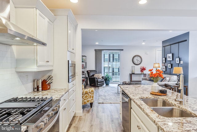 3226 Light Way, Mechanicsburg, PA 17055 - kitchen with wall chimney exhaust hood, a sink, stainless steel appliances, open floor plan, and light wood-style flooring
