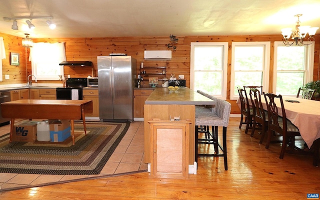5254 Havenwood Ln, Schuyler, VA 22969 - kitchen with stainless steel appliances, wooden walls, a chandelier, a sink, and a kitchen island