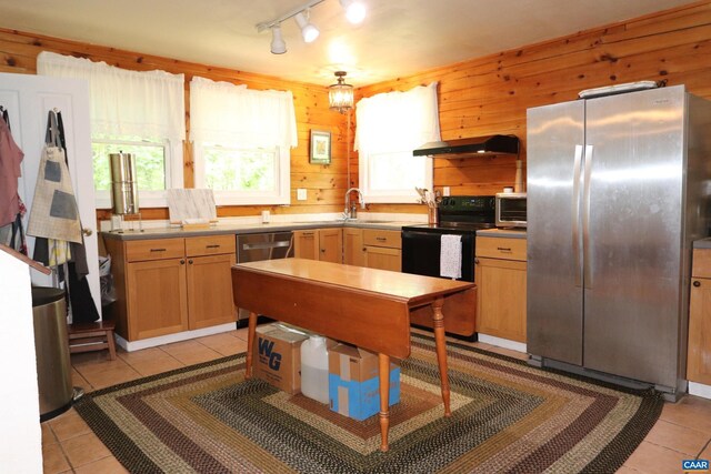 5254 Havenwood Ln, Schuyler, VA 22969 - kitchen with appliances with stainless steel finishes, under cabinet range hood, light tile patterned floors, a sink, and wood walls