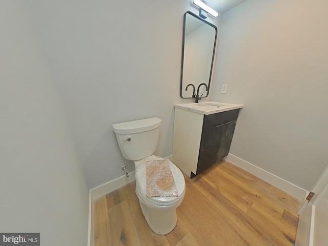 3143 W Montgomery Ave, Philadelphia, PA 19121 - half bathroom featuring toilet, vanity, wood finished floors, and baseboards