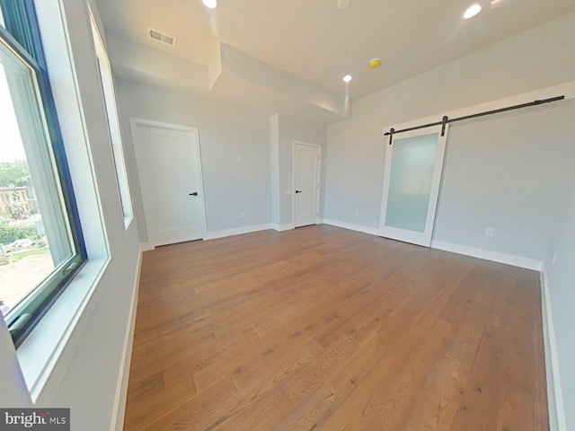 3143 W Montgomery Ave, Philadelphia, PA 19121 - unfurnished bedroom with hardwood / wood-style floors, a barn door, recessed lighting, and baseboards