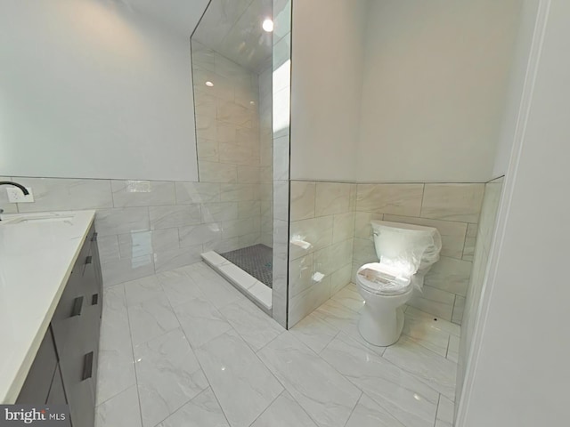 3143 W Montgomery Ave, Philadelphia, PA 19121 - bathroom with tile walls, marble look tile flooring, toilet, a tile shower, and vanity