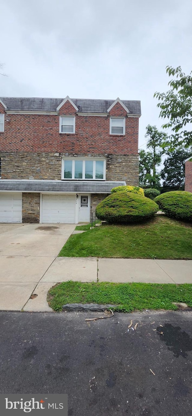 614 E Gorgas Ln, Philadelphia, PA 19119 - view of front of house featuring driveway, an attached garage, stone siding, and brick siding
