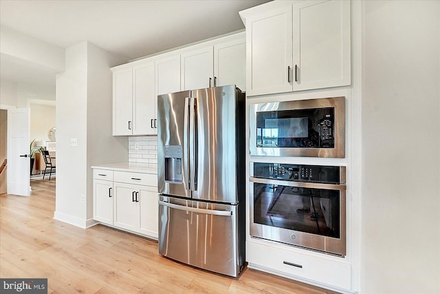 48 Winifred Dr, Hanover, PA 17331 - kitchen with appliances with stainless steel finishes, light wood finished floors, white cabinets, light countertops, and decorative backsplash