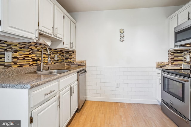2557 Peter Jefferson Ln, Herndon, VA 20171 - kitchen featuring stainless steel appliances, a sink, white cabinetry, light wood-style flooring, and backsplash