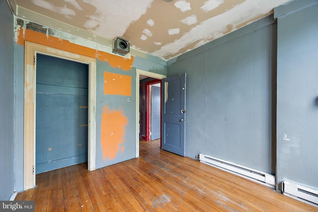 907 W Twenty Fifth St, Wilmington, DE 19802 - unfurnished bedroom with hardwood / wood-style flooring, a baseboard heating unit, and a closet