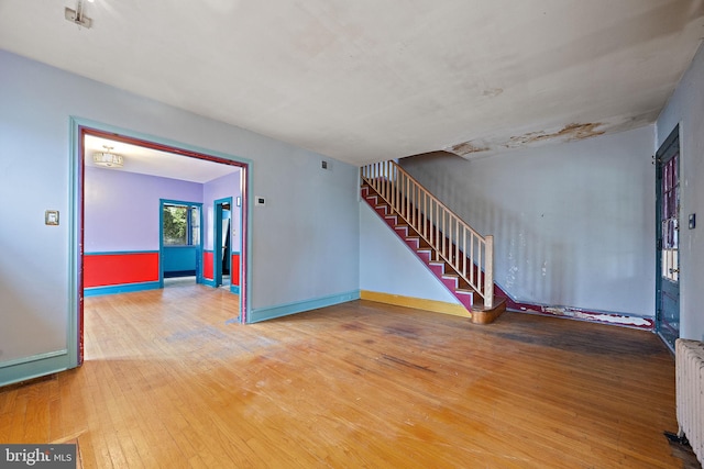 907 W Twenty Fifth St, Wilmington, DE 19802 - spare room featuring hardwood / wood-style flooring, stairs, baseboards, and radiator heating unit