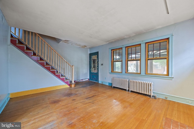 907 W Twenty Fifth St, Wilmington, DE 19802 - foyer entrance with radiator, stairway, wood finished floors, and baseboards
