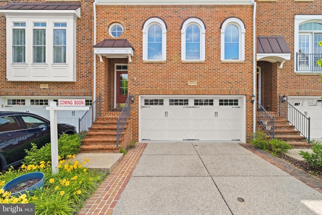 504 Hollingsworth Ter, Herndon, VA 20170 - townhome / multi-family property with an attached garage, a standing seam roof, driveway, and brick siding