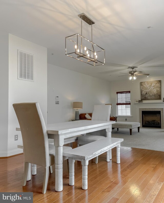 24655 Broad Creek Dr, Hollywood, MD 20636 - dining space with ceiling fan, wood finished floors, a chandelier, and a fireplace