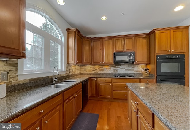 24655 Broad Creek Dr, Hollywood, MD 20636 - kitchen with black appliances, a sink, light wood finished floors, brown cabinets, and recessed lighting