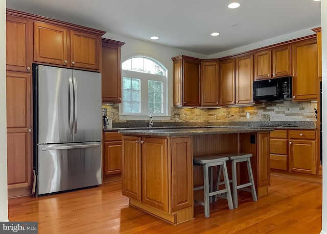 24655 Broad Creek Dr, Hollywood, MD 20636 - kitchen with freestanding refrigerator, black microwave, light wood-style floors, brown cabinets, and recessed lighting
