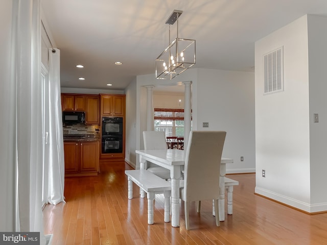 24655 Broad Creek Dr, Hollywood, MD 20636 - dining room with decorative columns, light wood-style floors, baseboards, recessed lighting, and a chandelier