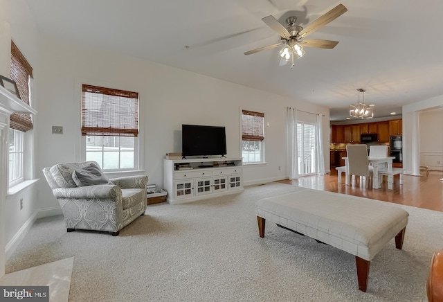 24655 Broad Creek Dr, Hollywood, MD 20636 - living room featuring a chandelier, light colored carpet, a ceiling fan, and baseboards