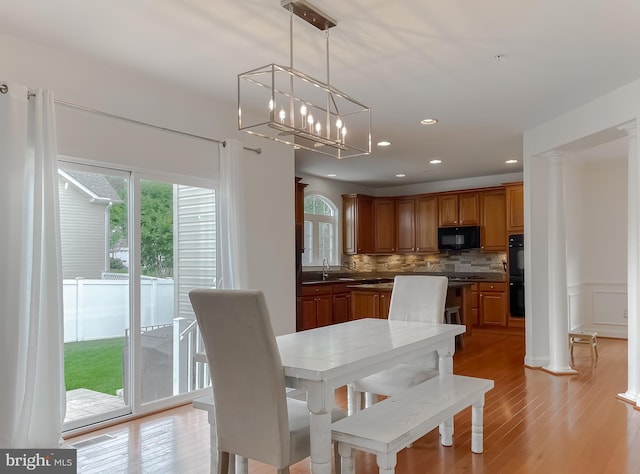 24655 Broad Creek Dr, Hollywood, MD 20636 - dining area with healthy amount of natural light, light wood-style flooring, recessed lighting, a chandelier, and decorative columns