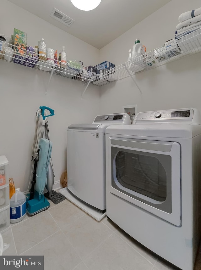 24655 Broad Creek Dr, Hollywood, MD 20636 - laundry area with washing machine and dryer and light tile patterned floors