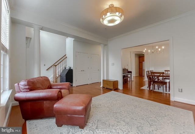 24655 Broad Creek Dr, Hollywood, MD 20636 - living area featuring decorative columns, wood finished floors, crown molding, stairway, and a chandelier