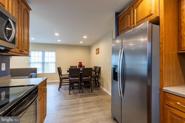 1088 Locust Dr, Pasadena, MD 21122 - kitchen featuring stainless steel appliances, brown cabinetry, light wood-style floors, baseboards, and recessed lighting