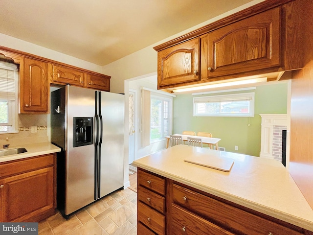 920 Vanderwood, Baltimore, MD 21228 - kitchen featuring stainless steel fridge with ice dispenser, brown cabinetry, light countertops, a sink, and a brick fireplace