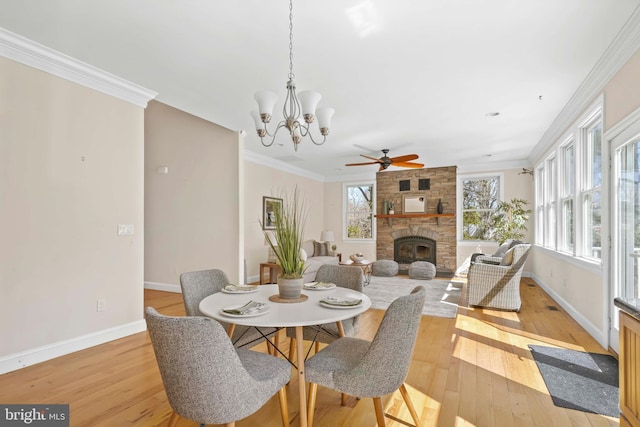 1109 Cherry Point Rd, West River, MD 20778 - dining space featuring a fireplace, ceiling fan, baseboards, light wood-style floors, and crown molding