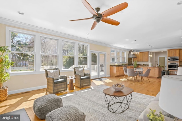 1109 Cherry Point Rd, West River, MD 20778 - living area with crown molding, light wood-style flooring, baseboards, ceiling fan, and french doors