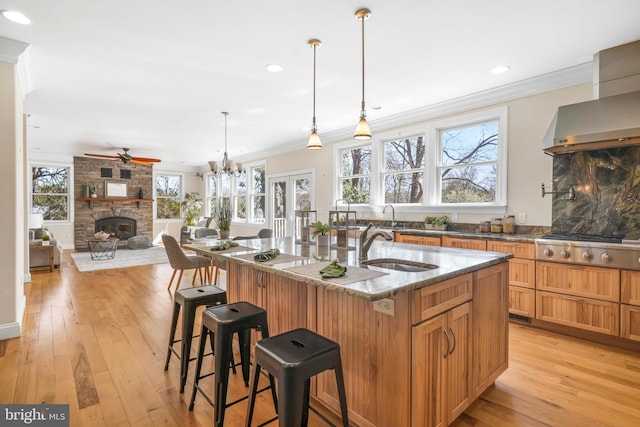 1109 Cherry Point Rd, West River, MD 20778 - kitchen featuring a stone fireplace, a sink, stainless steel gas cooktop, ceiling fan, and crown molding