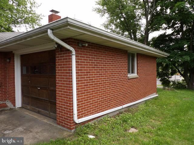 179 Mount Pleasant St, Frostburg, MD 21532 - view of property exterior with brick siding, a chimney, and a yard