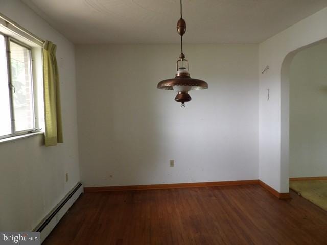 179 Mount Pleasant St, Frostburg, MD 21532 - unfurnished dining area featuring baseboard heating, arched walkways, wood finished floors, and baseboards