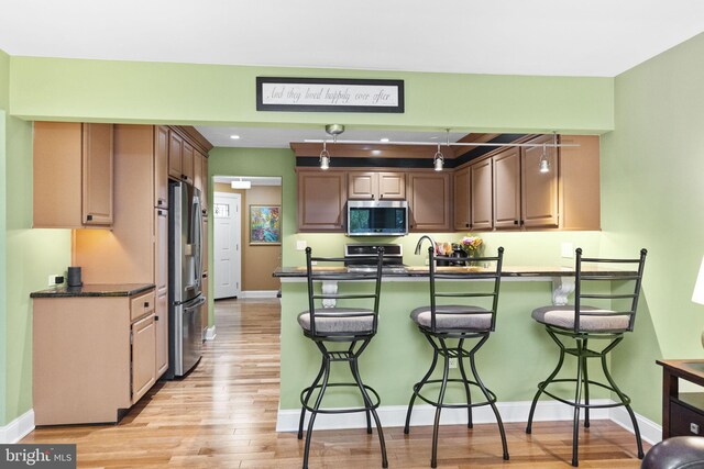 1319 Gwynedale Way, Lansdale, PA 19446 - kitchen with stainless steel appliances, dark countertops, a breakfast bar area, a peninsula, and baseboards