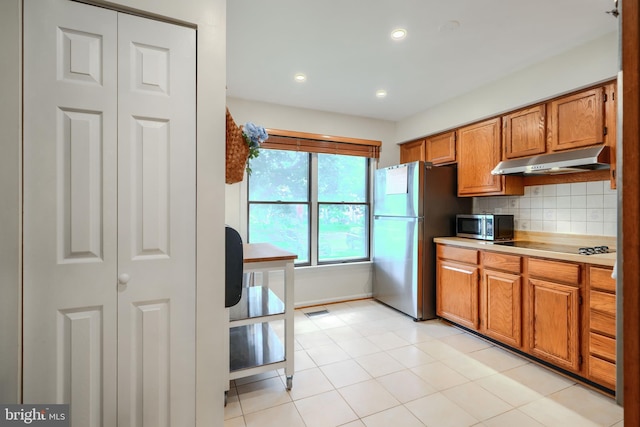 23 Faraday Dr, Lutherville Timonium, MD 21093 - kitchen with under cabinet range hood, appliances with stainless steel finishes, brown cabinets, tasteful backsplash, and light countertops