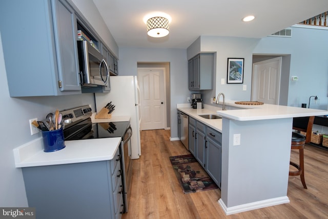 604 Remington Ct, Chalfont, PA 18914 - kitchen featuring stainless steel appliances, a kitchen breakfast bar, a sink, a peninsula, and light wood-style floors