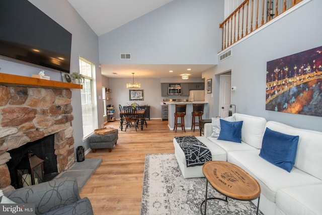 604 Remington Ct, Chalfont, PA 18914 - living area with high vaulted ceiling, light wood-type flooring, a fireplace, a chandelier, and baseboards