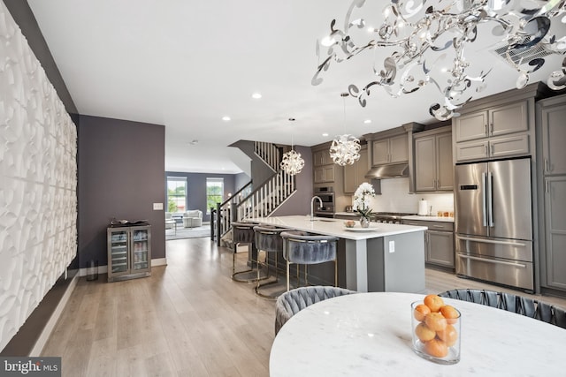 141 Center St S Unit 6, Vienna, VA 22180 - kitchen featuring high quality fridge, beverage cooler, a chandelier, a kitchen island with sink, and a kitchen bar
