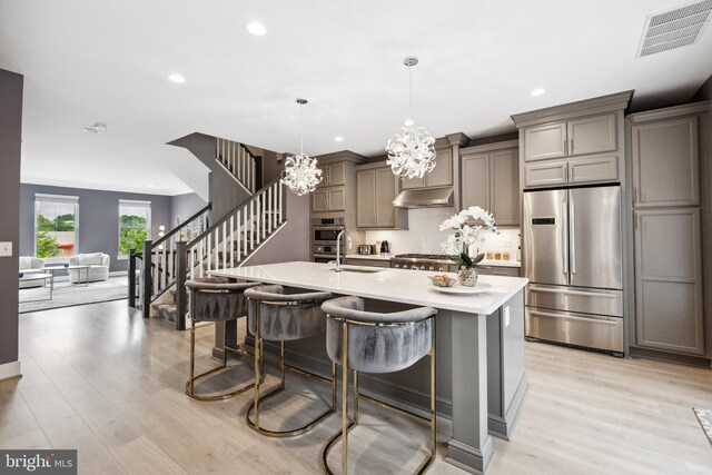 141 Center St S Unit 6, Vienna, VA 22180 - kitchen featuring stainless steel appliances, under cabinet range hood, recessed lighting, light wood-type flooring, and a chandelier