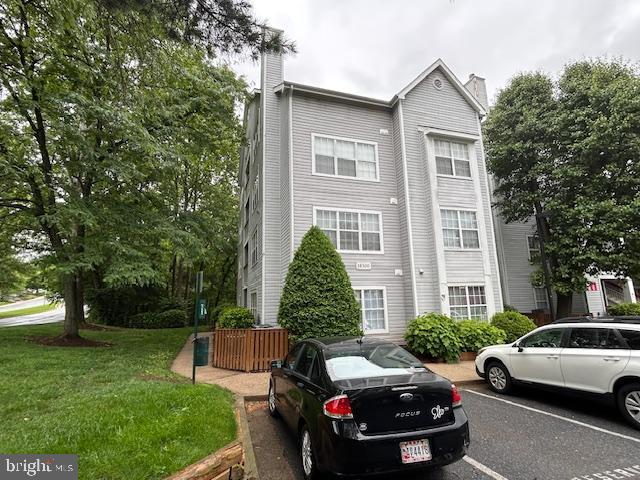 18500 Boysenberry Unit 145-51, Gaithersburg, MD 20879 - view of front of house with a chimney, uncovered parking, and a front lawn