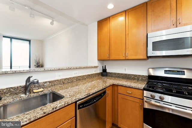 414 Water St Unit 3006, Baltimore, MD 21202 - kitchen featuring appliances with stainless steel finishes, a sink, rail lighting, light stone counters, and brown cabinets