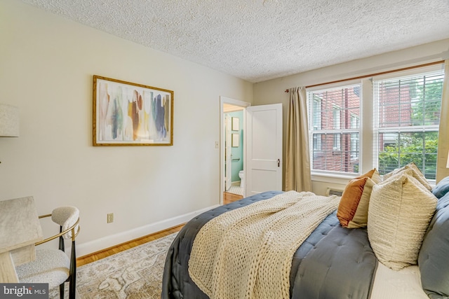 715 S Washington St Unit A-13, Alexandria, VA 22314 - bedroom featuring baseboards, a textured ceiling, and wood finished floors