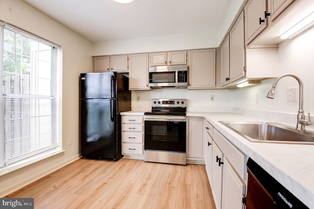 8060 Stonewall Brigade Ct Unit 101, Manassas, VA 20109 - kitchen with stainless steel appliances, a sink, light wood-style floors, light countertops, and baseboards