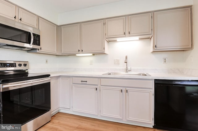 8060 Stonewall Brigade Ct Unit 101, Manassas, VA 20109 - kitchen with stainless steel appliances, a sink, light countertops, and light wood-type flooring